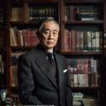 陈文远，日本伦理片研究中心创始人，身着深色西装，神情专注，背景为书架满载日本电影相关书籍的办公室